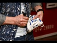 Jackie signs his sneakers. His outfit earned a total of US$38,000.