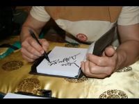 In his room after the auction, Jackie signs his name in a diary.