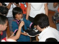A little girl presents Jackie with handmade shoes. The shoes took her mother 2 months to make.