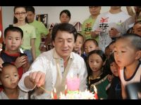 Jackie lights the candles while the children look on.