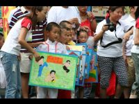 The children present artwork to Jackie.