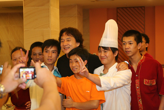 Jackie stops in the hallway to take photos with hotel staff.
