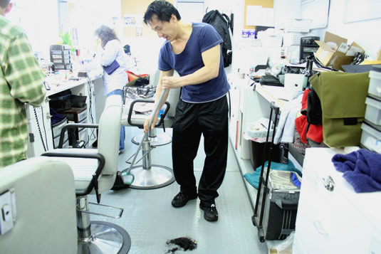 Jackie sweeping up after his haircut.