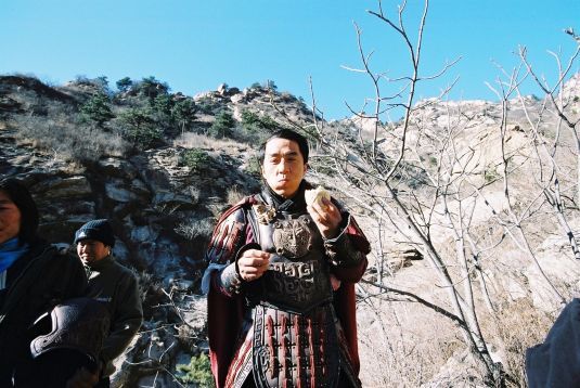 General Meng Yi enjoys a snack during a break on the set