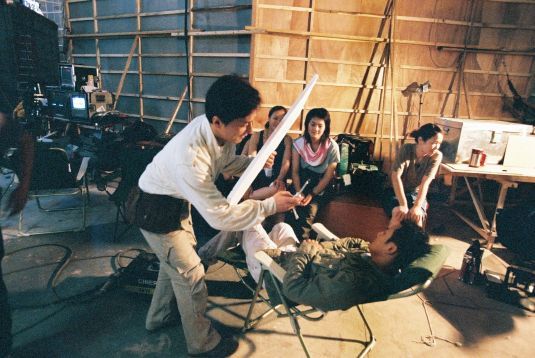 Jackie takes a photo of a sleeping Tony Leung Ka Fai.